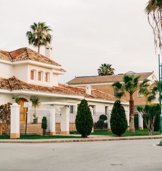 Charming villas with Mediterranean architecture in Málaga, Spain, lined with palm trees.